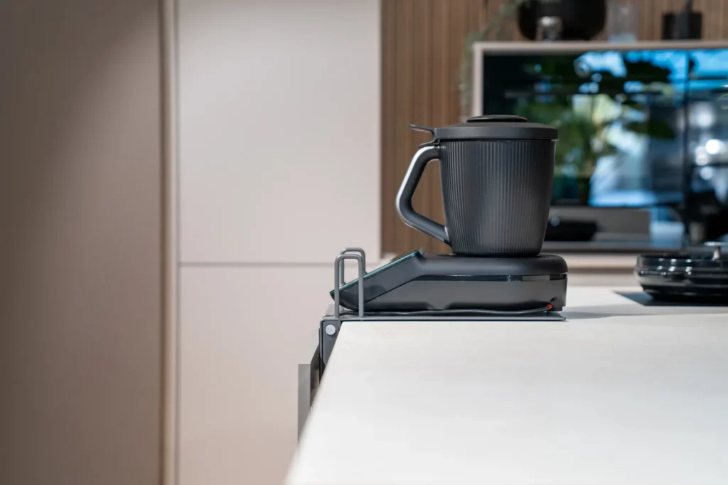 Seitenansicht: Thermomix TM7 auf der Maschinenplatte des INVISIBLE 2.0, bündig an der Arbeitsplattenkante